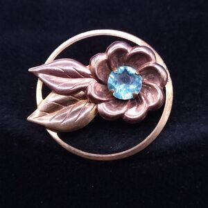 Vintage mid-century gold-tone flower brooch with an aqua blue rhinestone center.